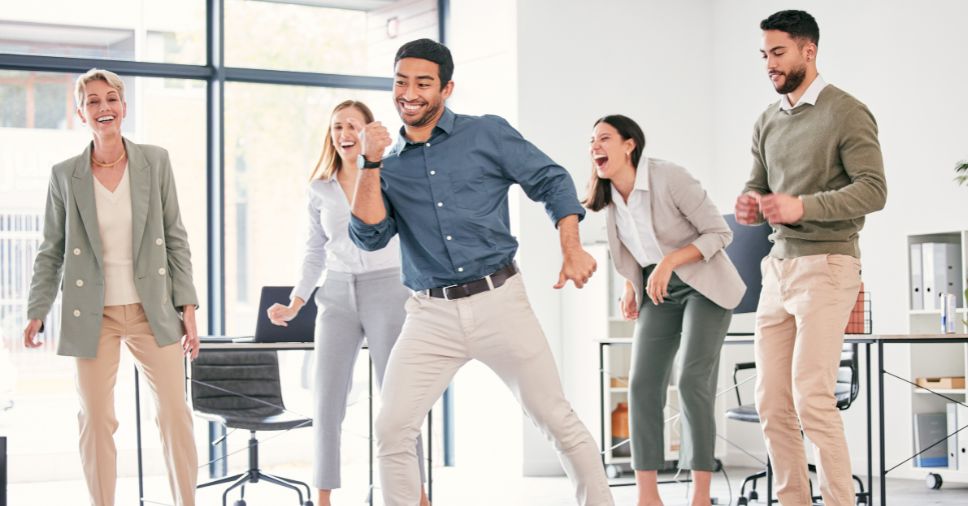 Funcionários praticando zumba para empresas.